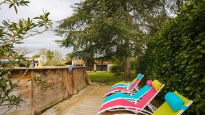 A row of colorful lounge chairs along a wooden deck, with a wooden fence and greenery in the background. - Gîte du Maroye with Pool (Montreuil)