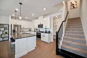 A modern kitchen with white cabinetry, stainless steel appliances, and a central island. - PL088 - Home|Yard|16mi to Convention Ctr|Sleeps 8 (Plano)