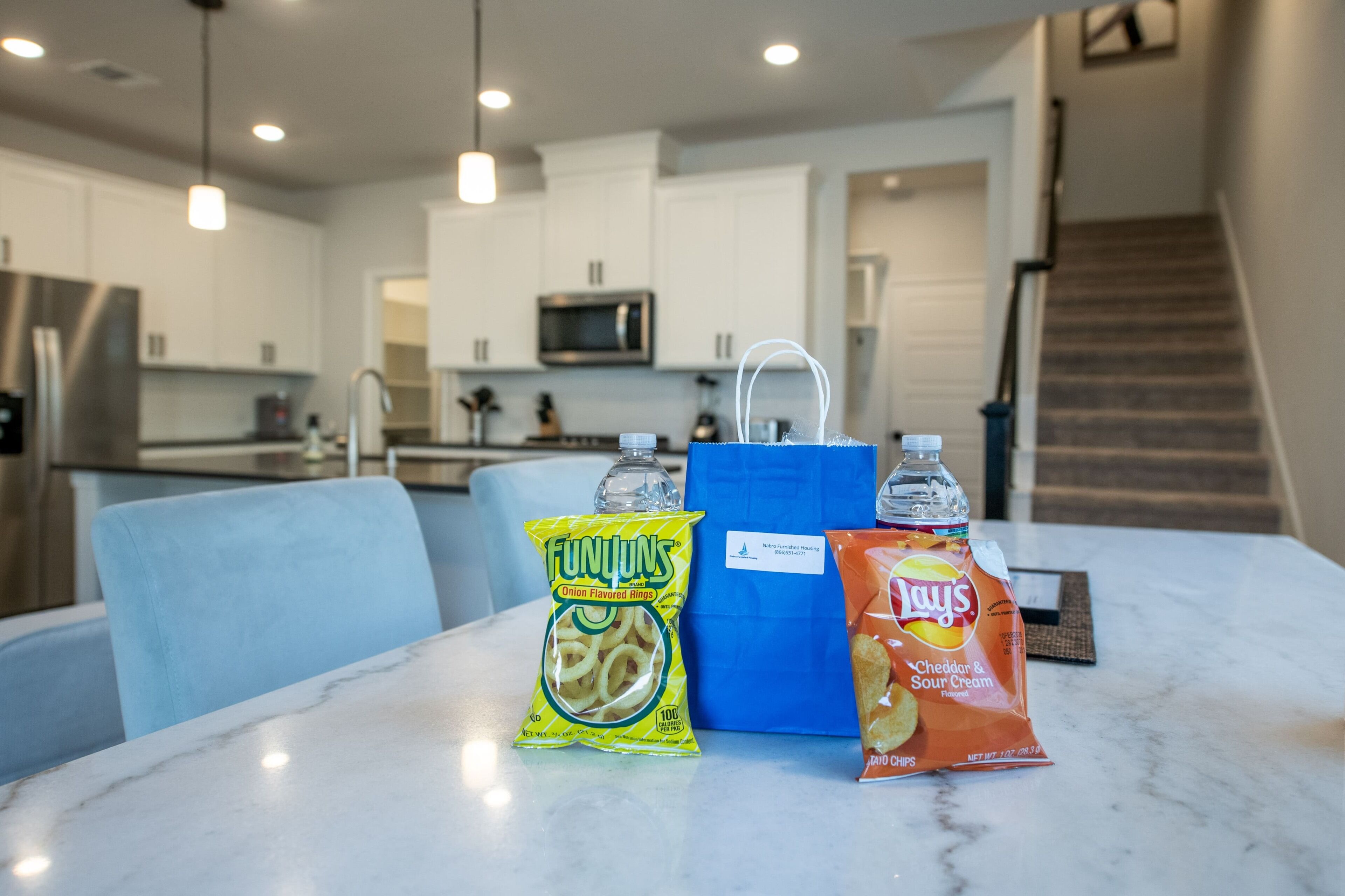 A kitchen with white cabinets, a microwave, and a stainless steel refrigerator.