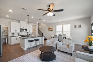 A modern kitchen with white cabinetry, a central island, and a ceiling fan. - PL088 - Home|Yard|16mi to Convention Ctr|Sleeps 8 (Plano)