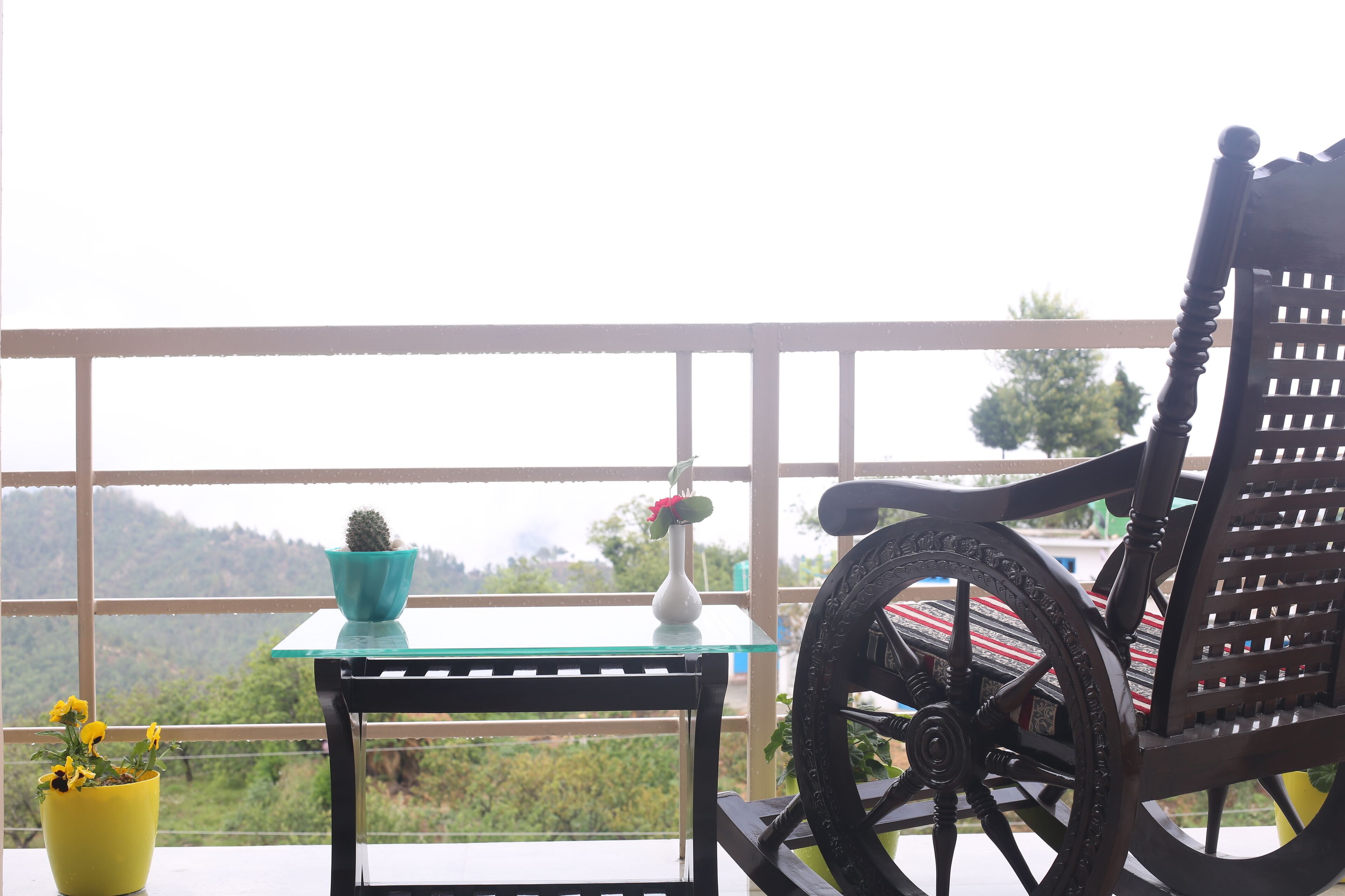 Un balcon avec une chaise, une petite table et des plantes en pot.