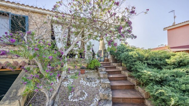 Una escala de pedra que mena a una casa amb jardí.
