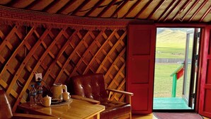 Ein gemütliches Interieur mit einem Holztisch und Stühlen, einer Bank und einer Tür, die nach draußen führt.