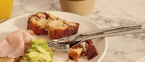 Una escena de desayuno con un plato de comida, una taza y un vaso de jugo de naranja sobre una mesa de mármol.