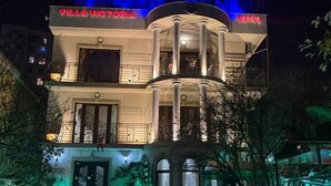 En bygning med flere etager, med skilt der siger "Villa Victoria Hotel".