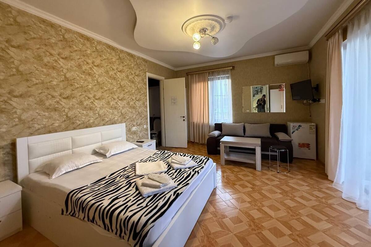 Une chambre avec un grand lit, un bureau, une chaise et un téléviseur.