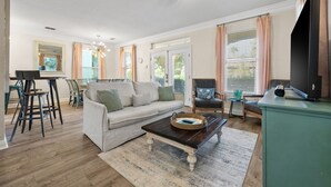 Ein geräumiges Wohnzimmer mit einer Couch, einem Couchtisch und einem Deckenventilator.