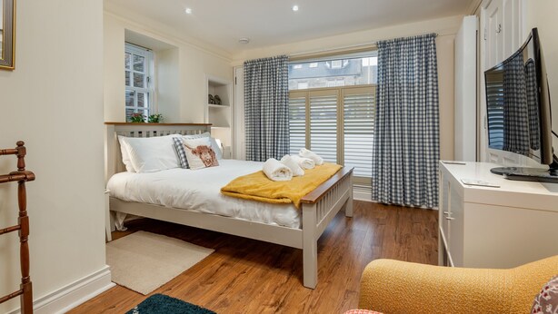 A bedroom with a bed, a desk, a chair, and a television. - Toll Green View | Elie (Elie)