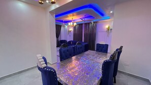 A conference room with a large table, blue upholstered chairs, and modern lighting. - 3BR High-Rise Apartment • Prime Location 12th floor (Mombasa)