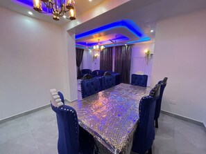 A conference room with a large table, blue upholstered chairs, and modern lighting. - 3BR High-Rise Apartment • Prime Location 12th floor (Mombasa)