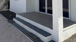 Un edificio moderno con techo plano, una ventana y un conjunto de puertas de vidrio doble.