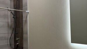 Un baño con ducha, inodoro y lavamanos.