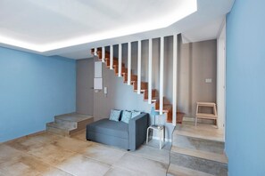 A modern room with a staircase, a sofa, and a small table. - Holiday Home 'Civico 32' with Sea View, Wi-Fi and Air Conditioning (Salerno)