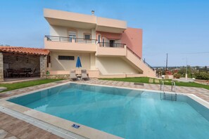 A modern two-story building with a swimming pool, outdoor seating, and a staircase leading to the upper floor. - Villa Pantelis With Private Pool (Rethymno)