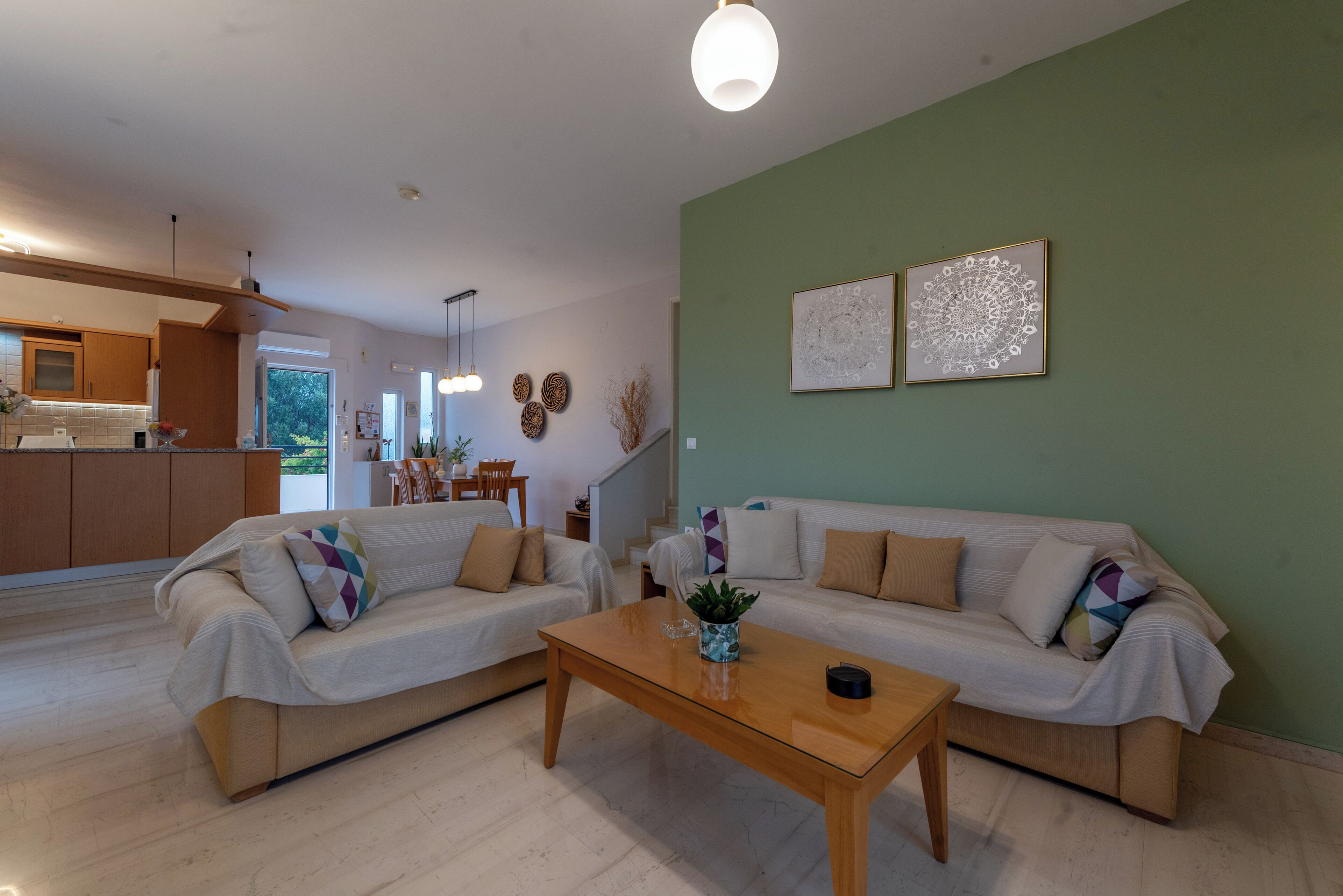 A modern living room with two sofas, a coffee table, and a dining area in the background.