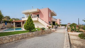 A modern two-story house with a stone wall, a swimming pool, and a well-maintained garden. - Villa Pantelis With Private Pool (Rethymno)