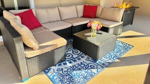 A sectional sofa with red and beige cushions, a small table with a vase of flowers, and a blue patterned rug. - 5/3 Pool Home In Central Lakeland, Pet Friendly! (Lakeland)