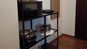 A kitchen area with a microwave, a pot on a shelf, and a framed picture on the wall. - Metro Angel Apartment 2 - 4 guests (Prague)