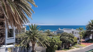 Una zona residenziale costiera con edifici moderni, palme e vista sull'oceano.