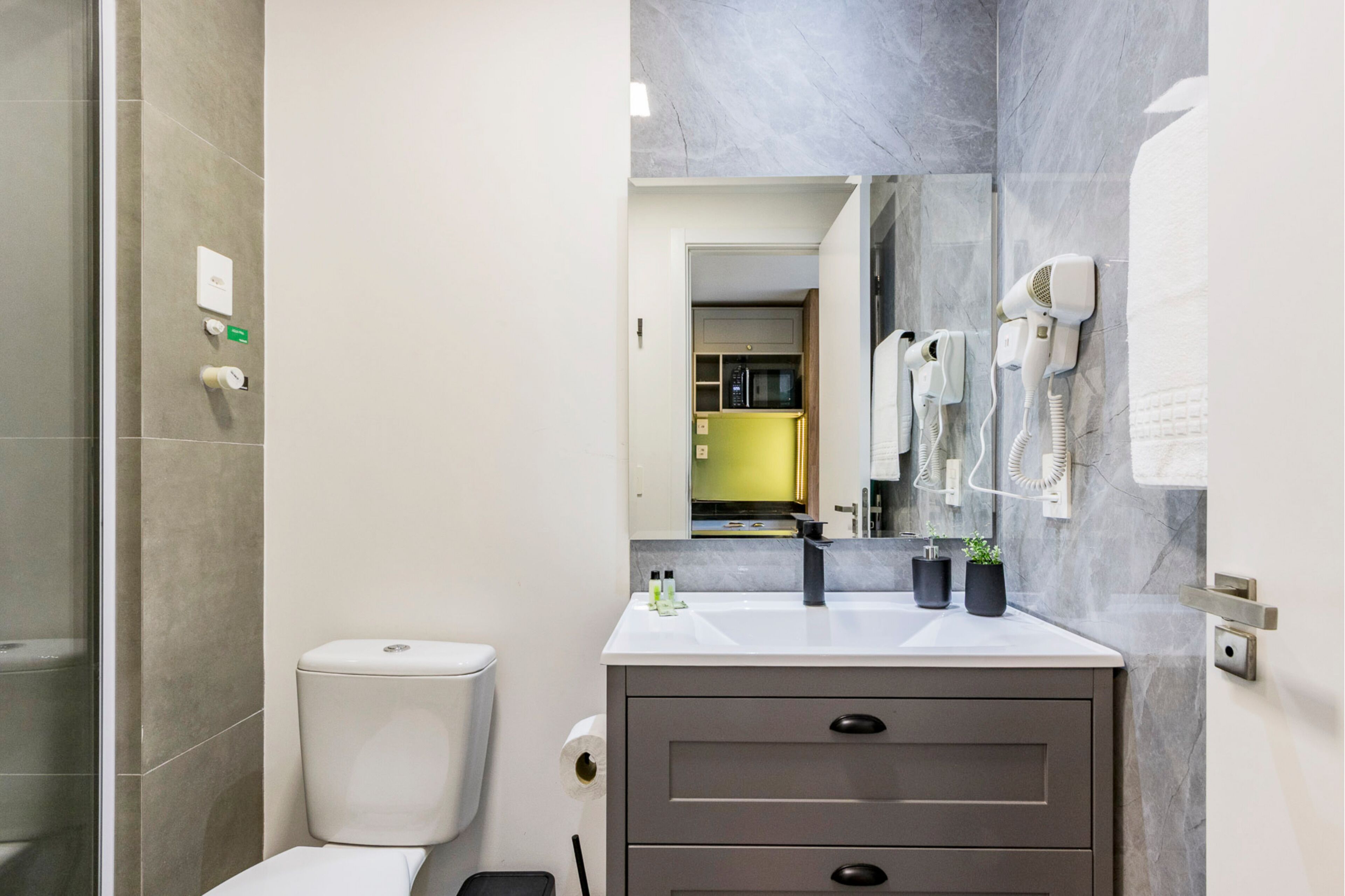 A modern bathroom with a toilet, sink, and mirror.