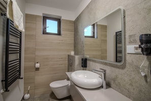 A modern bathroom with a toilet, sink, towel rack, and a window. - Casa Munteneasca Alessandro (Bradu)