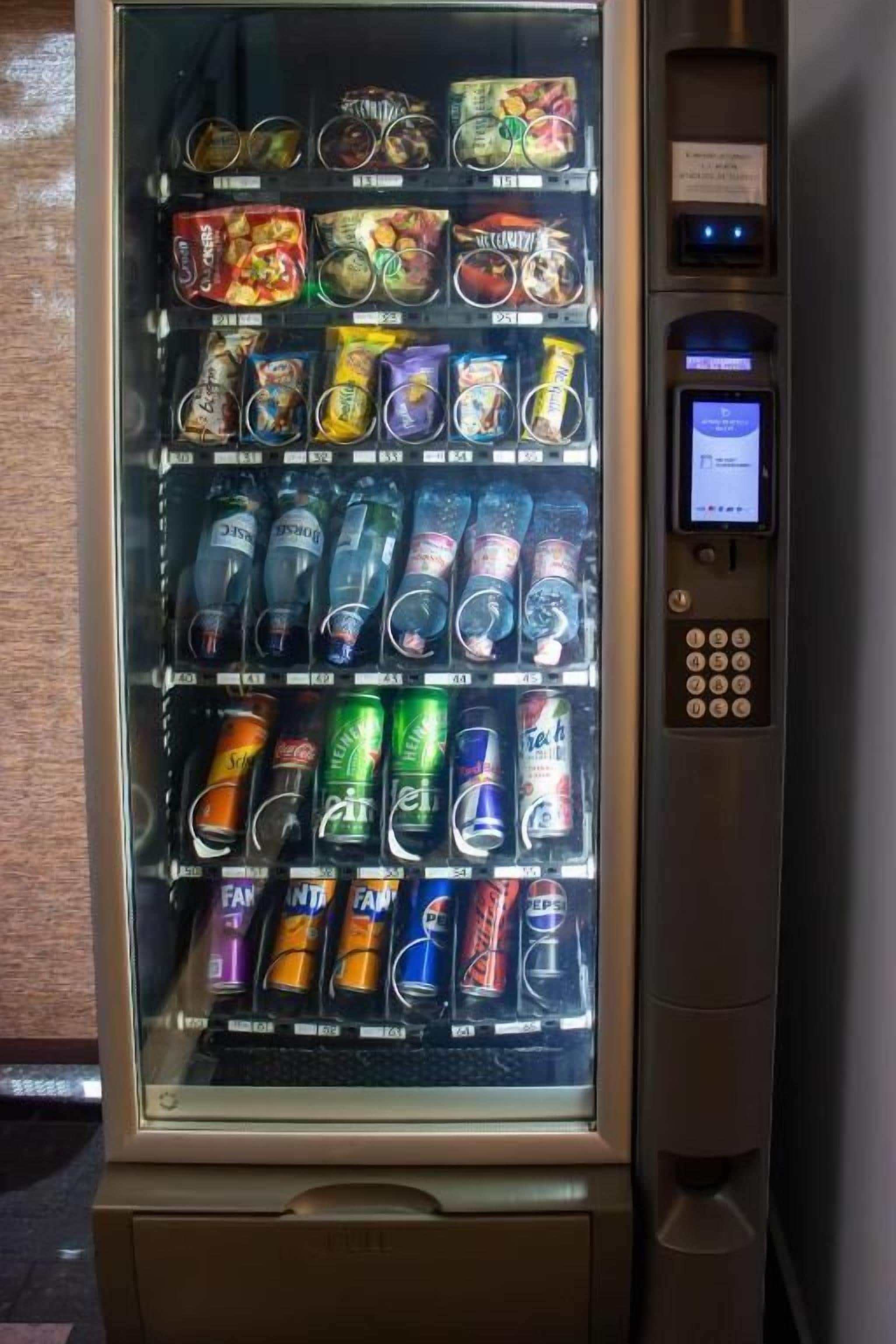 Una macchina distributrice con diverse merendine e bevande.