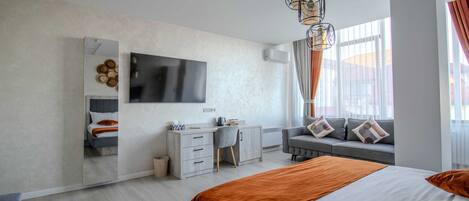 Una moderna camera d'albergo con un grande letto, una scrivania, una sedia, una TV e una finestra con tende.