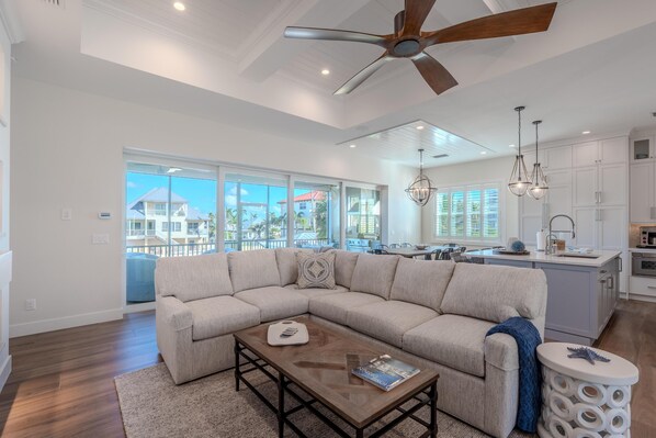 A spacious living room with a large sectional sofa, a wooden coffee table, and a ceiling fan. - Turtle Time (Fort Myers Beach)