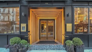 A modern hotel entrance with a glass door, a number '139' above the door, and a 'MERCHANT' sign on the right. - The Merchant Hotel Lower East Side (New York)