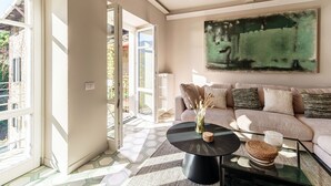 Un salon avec un canapé, une table basse et un tableau accroché au mur.