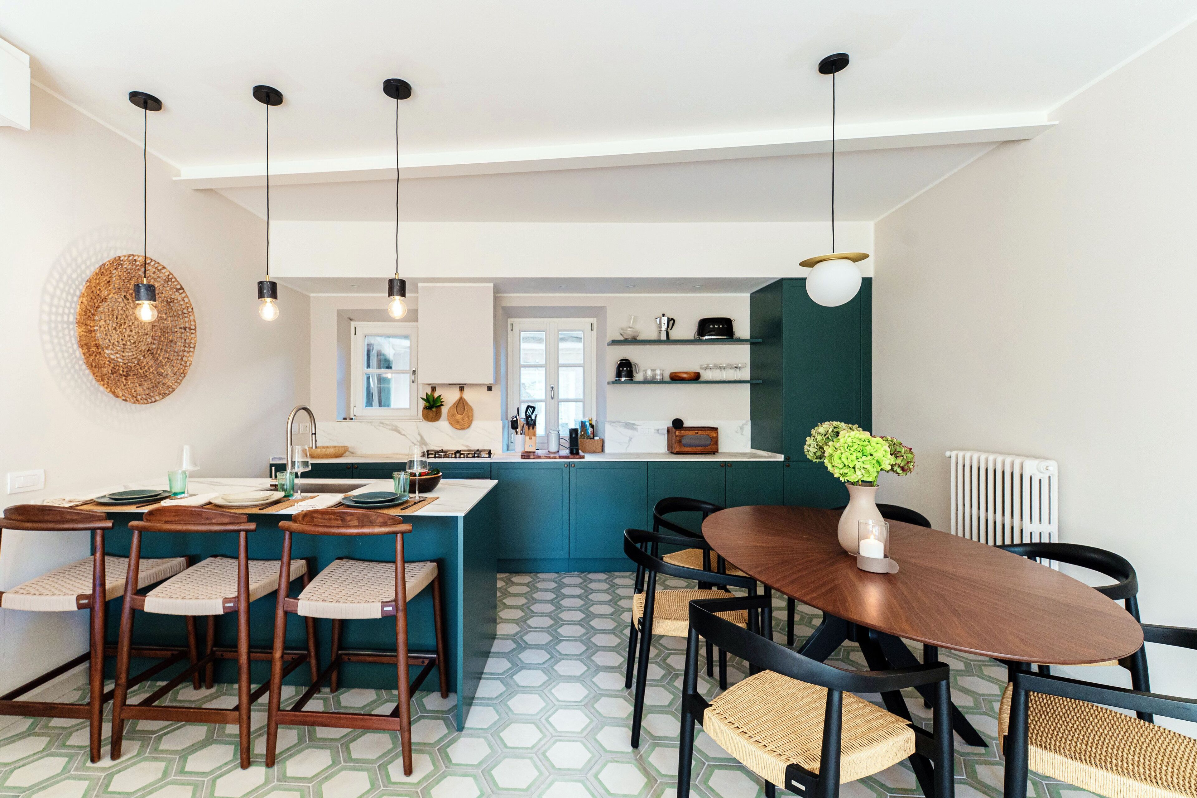 Una cocina moderna con una isla central, taburetes de bar y una mesa de comedor con sillas.