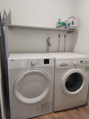 A laundry area with a front-loading beko washer and a front-loading Siemens dryer.