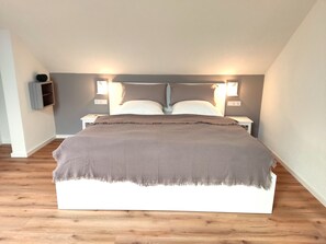 Un dormitorio con cama, mesitas de noche y lámparas de pared.