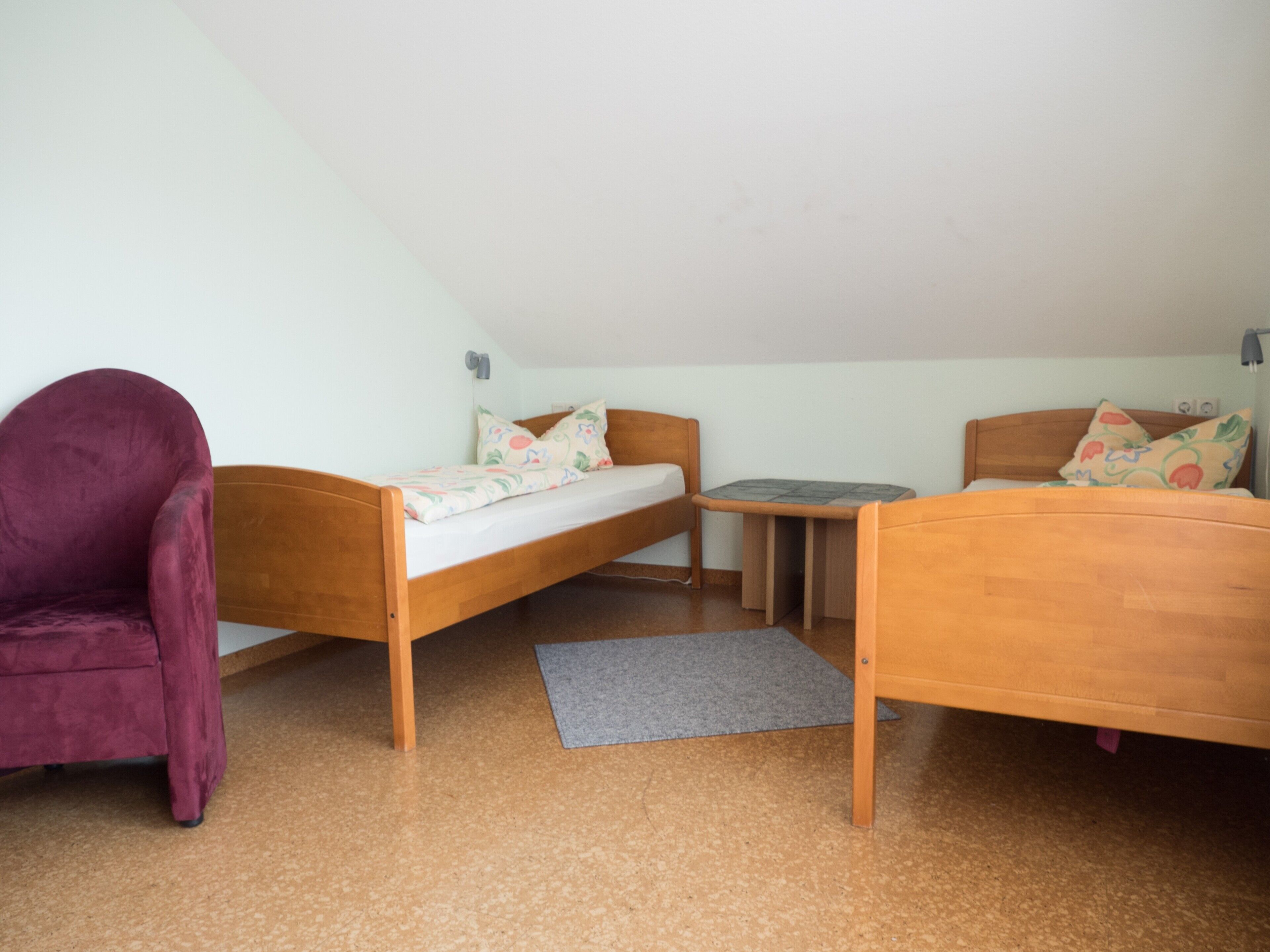 Un petit logement composé d’une seule pièce, comprenant un lit, une chaise, une petite table et un bureau.