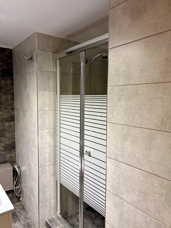A modern bathroom with a glass-enclosed shower, tiled walls, and a visible toilet. - Domus Philippou Tsimiski II, center of Thessaloniki (Thessaloniki)