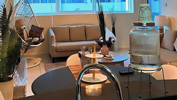 Ein modernes Wohnzimmer mit einer Couch, einem Hängesessel und einem großen Fenster.