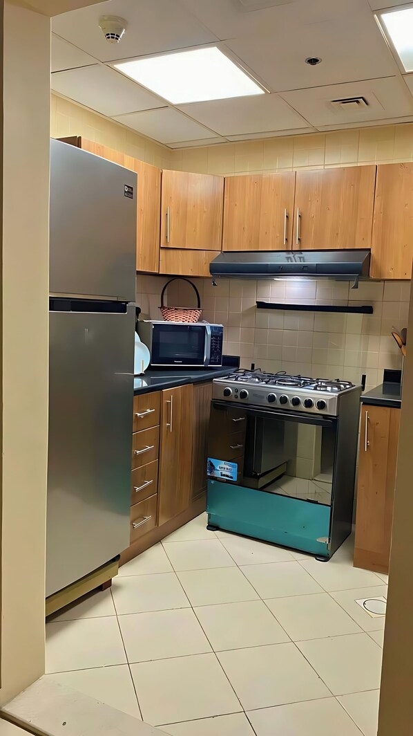 Departamento superior, balcón, vista a la ciudad | Cocina privada | Refrigerador con congelador, microondas, horno y utensilios de cocina 