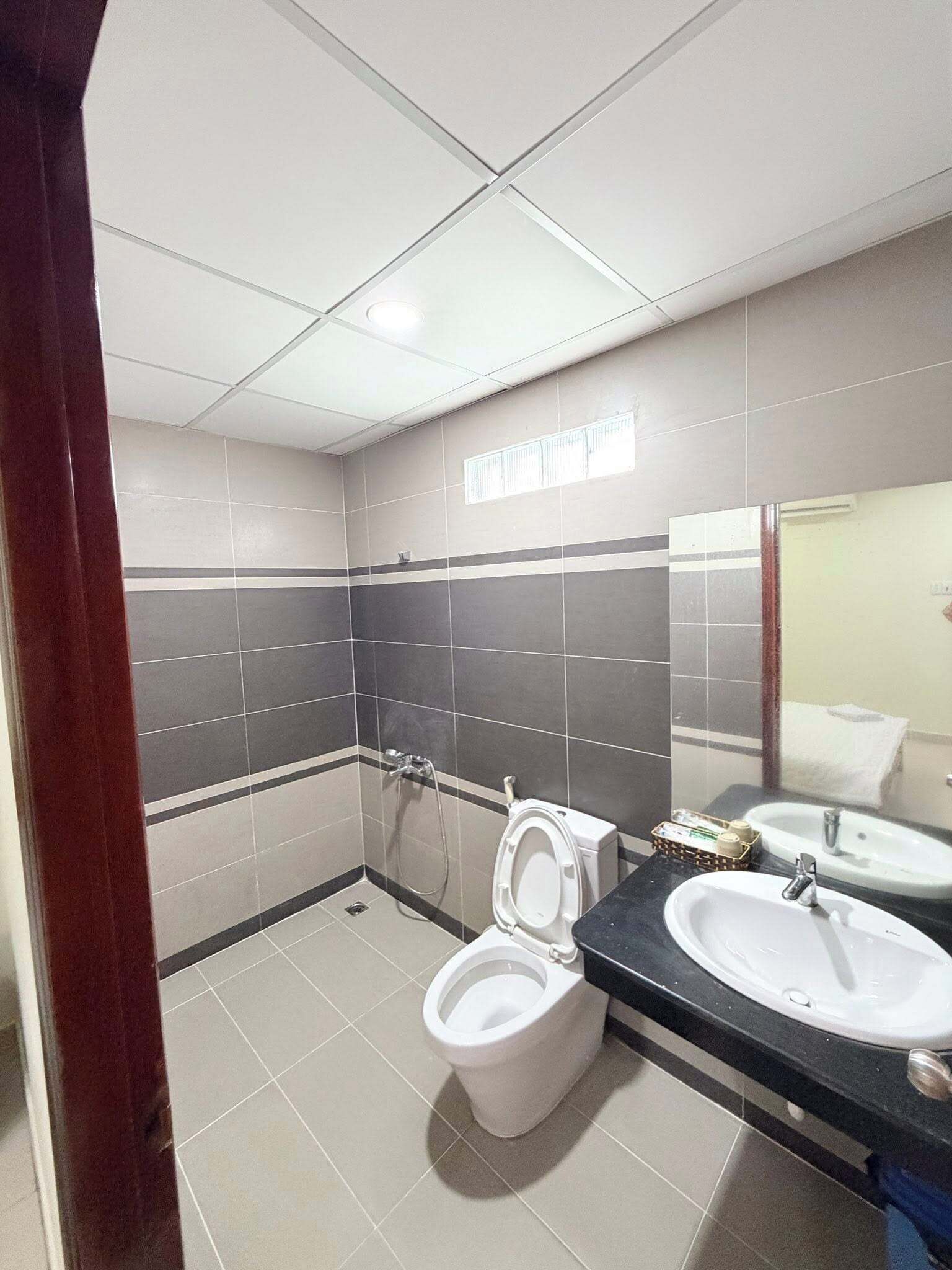 A modern bathroom with a toilet, bidet, and two sinks.