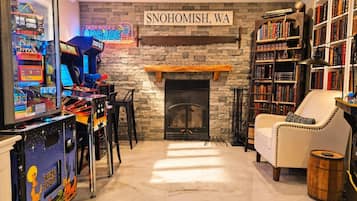 Ein gemütliches Zimmer mit Kamin, Spielhallenspielen, einem Bücherregal und einem Schild mit der Aufschrift 'SNOHOMISH, WA'.