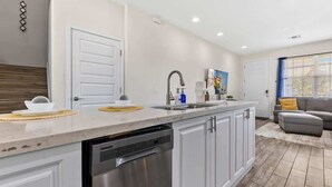A modern kitchen with a dishwasher, a sink, and a countertop. - Pool * Game Room * Mins to Disney (Kissimmee)