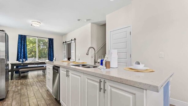 A modern kitchen with a central island, built-in appliances, and a dining area with a bench. - Pool * Game Room * Mins to Disney (Kissimmee)