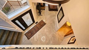 A high-ceilinged interior with a circular light fixture, a patterned rug, and a view of the outdoors through a window. - Private Bedroom w Hot Tub and Arcade (Snohomish)