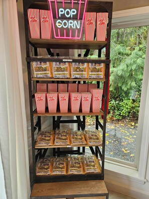 A display of All-N-One Premium Tri-Pak popcorn in red and white striped boxes and bags. - Private Bedroom w Hot Tub and Arcade (Snohomish)