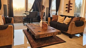 Un salon spacieux avec un grand piano, une table basse et un canapé.