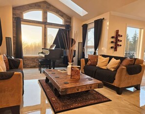 A spacious living room with a grand piano, a coffee table, and a sofa.
