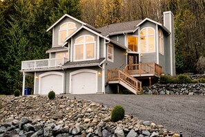 A two-story house with a stone foundation, a balcony, and a garage.