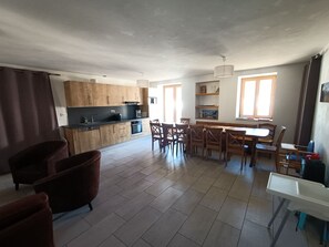 A spacious living area with a kitchen, dining table, and chairs. - Magnificent house Le Clos Marie appart. Sainte Marguerite for 13 people (Le Monêtier-les-Bains)