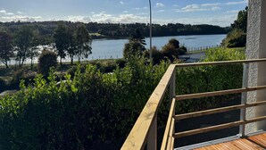 Vista de un lago con una plataforma de madera y un farol.