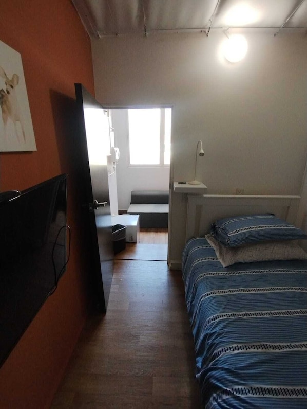 A bedroom with a bed, a desk, a chair, and a television. - Smile Center Hube (Mexico City)