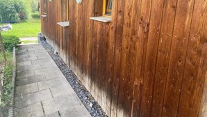 Un edificio in legno con un portico coperto e un sentiero che vi conduce.